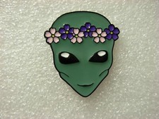 Listing image for Alien woman pin badge. Flowers in her hair. Metal. Martian, Area 51 Roswell